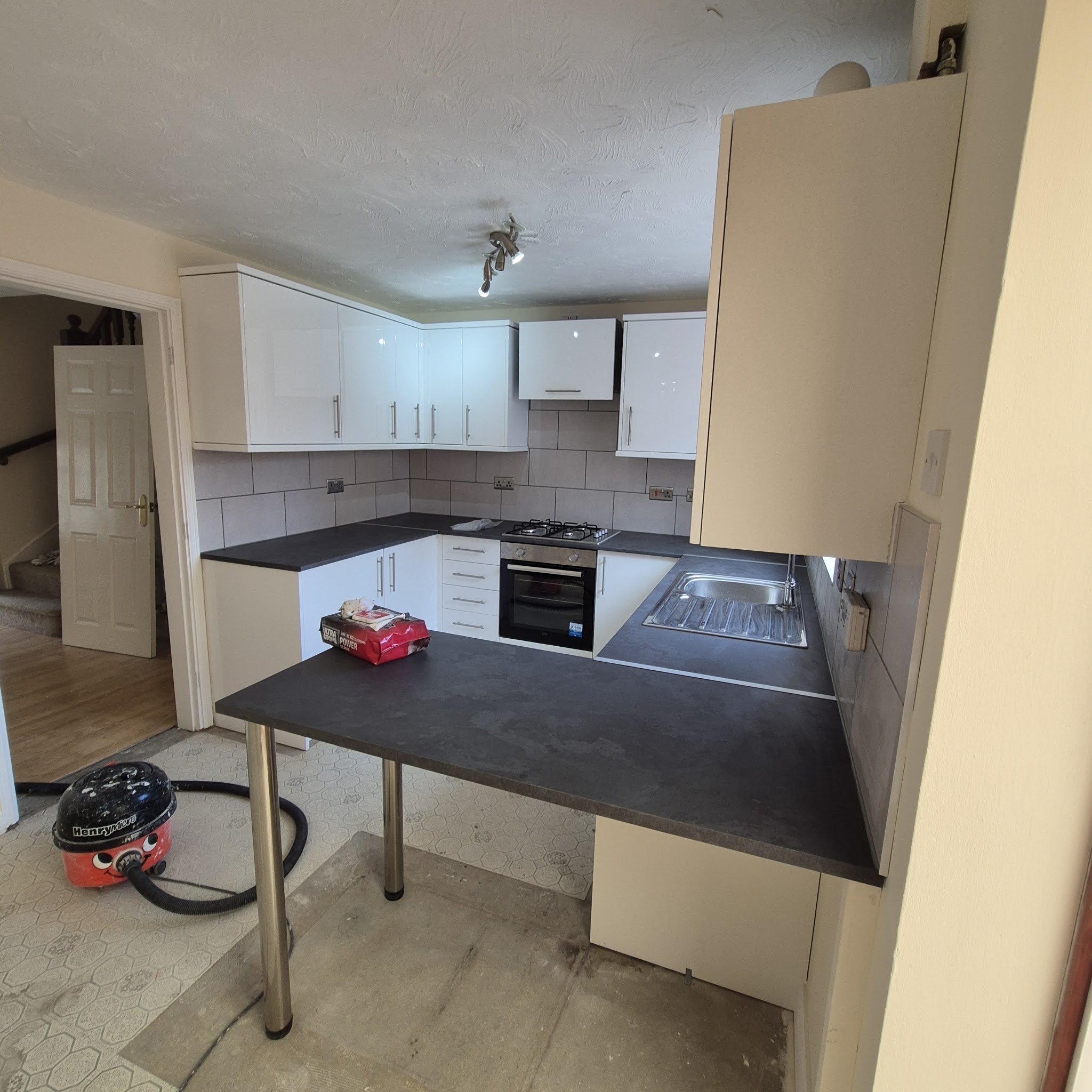 Kitchen with white units and a dark worktop