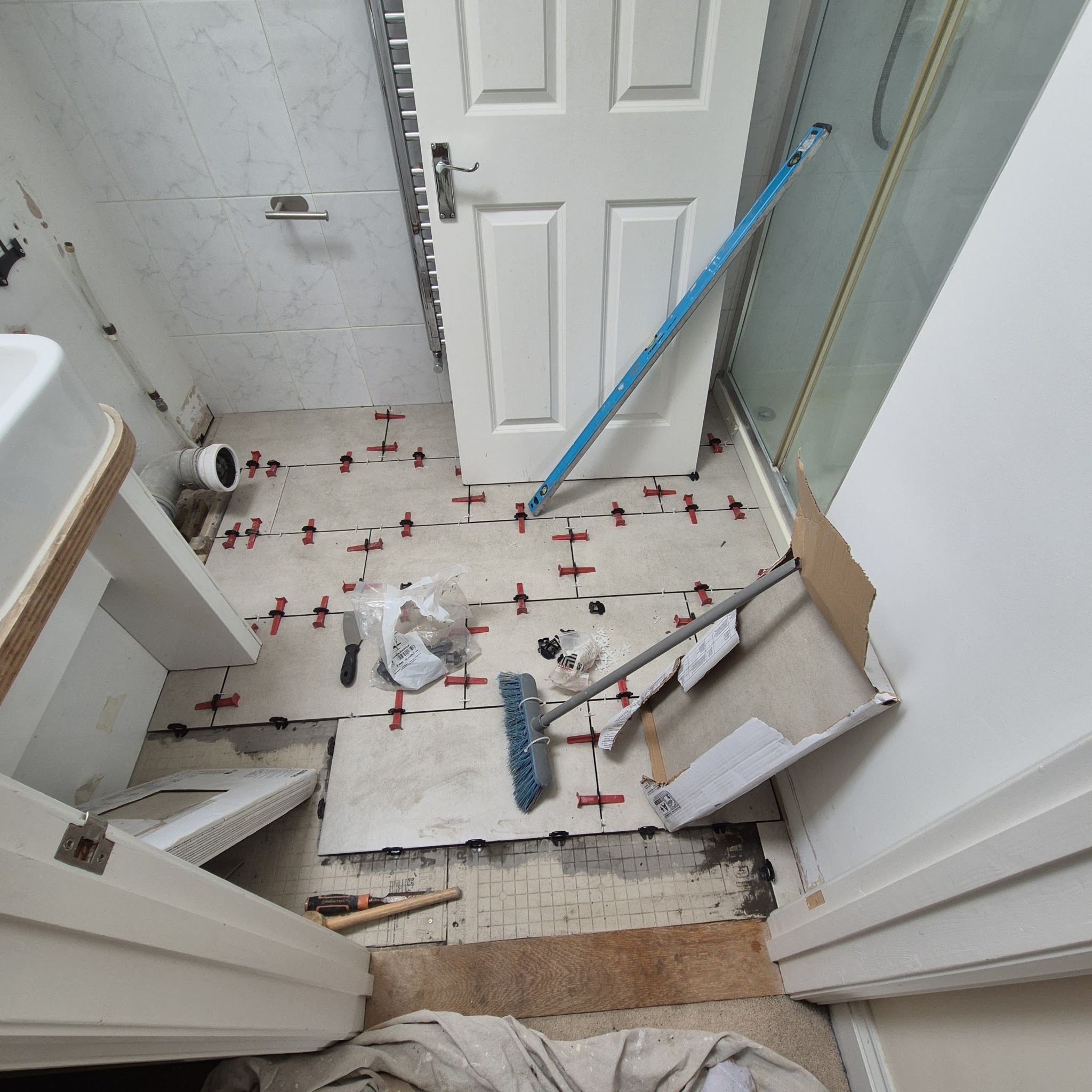 Bathroom floor being tiled with levelling clips