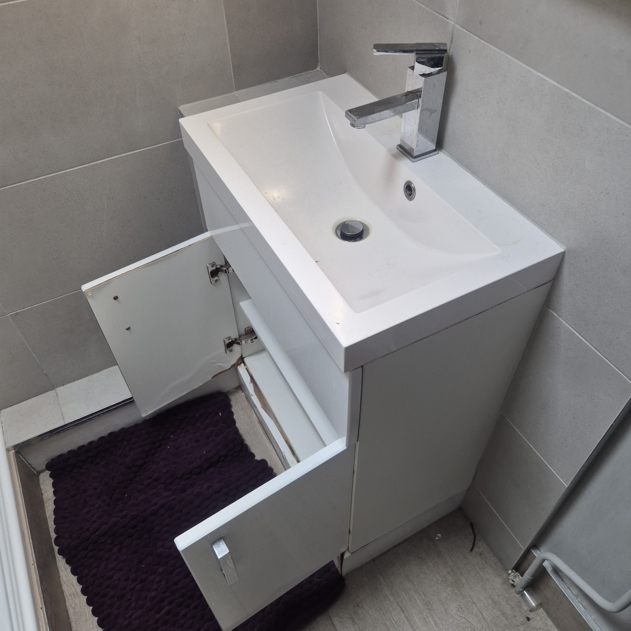 New white vanity basin unit with a chrome mixer tap in a tiled bathroom