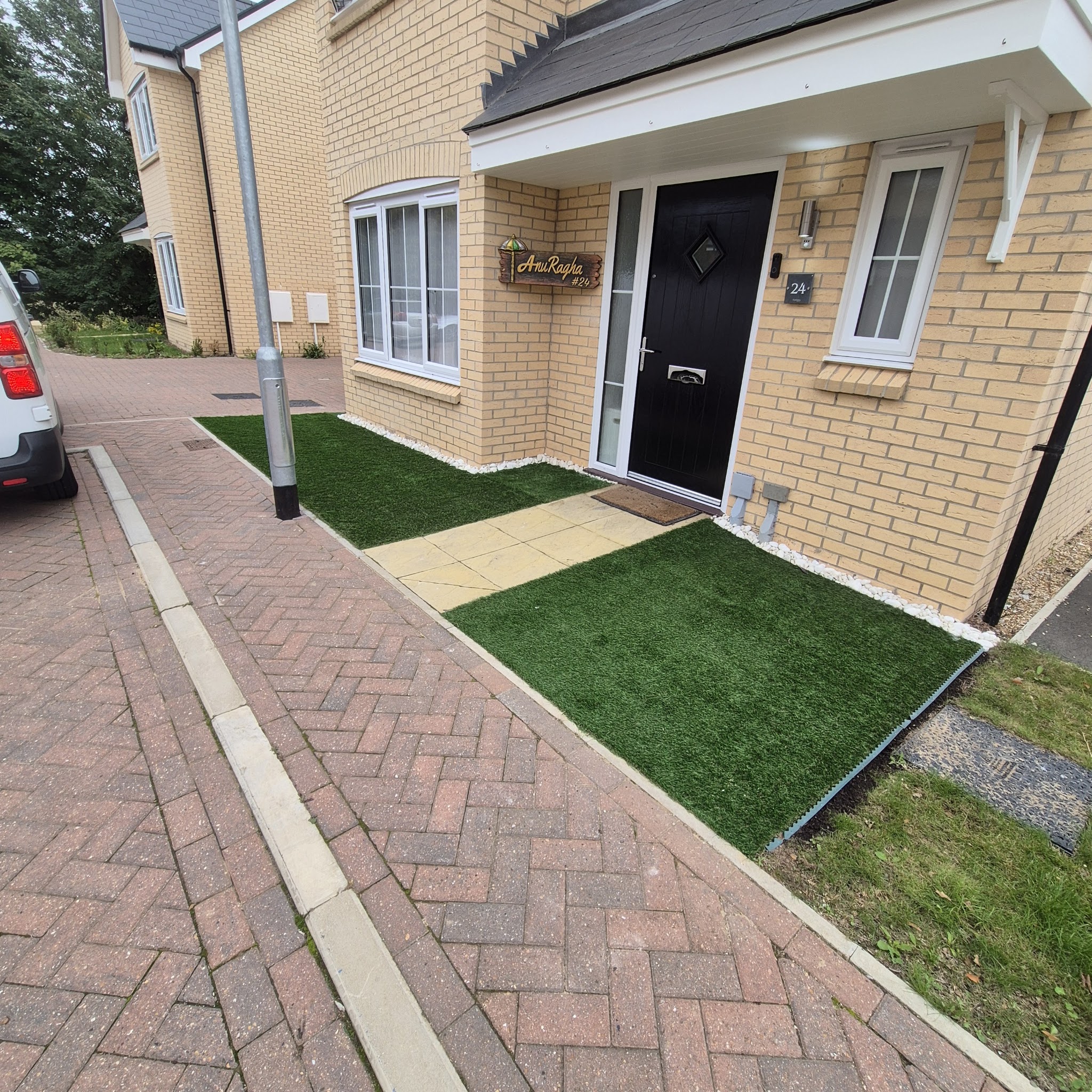 Block-paved path and artificial grass at a new-build front door