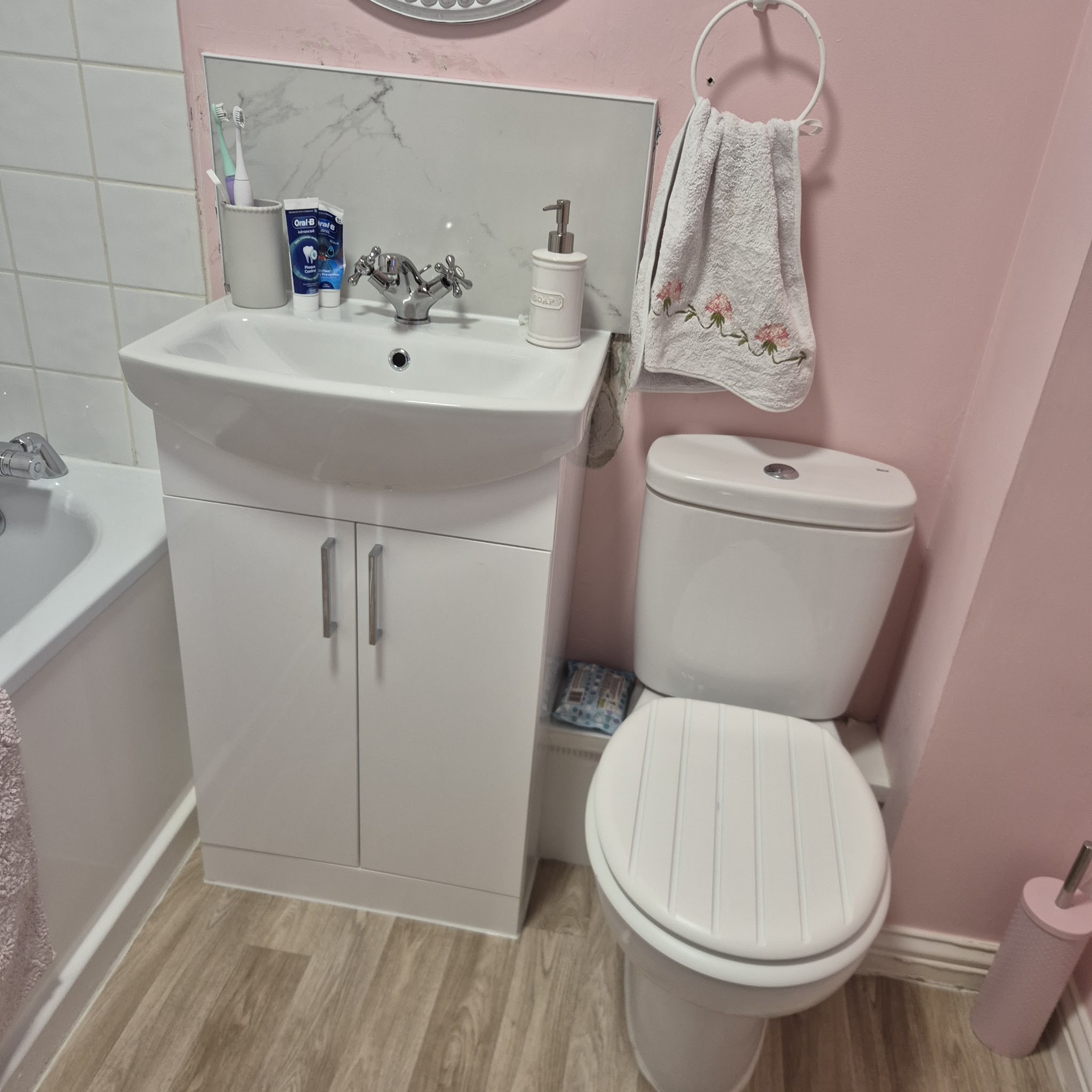 Pink bathroom with a new basin unit and WC