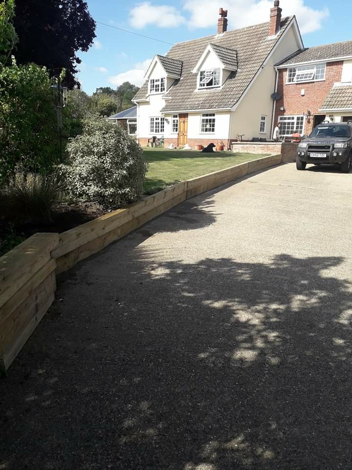Long gravel driveway edged with timber sleepers
